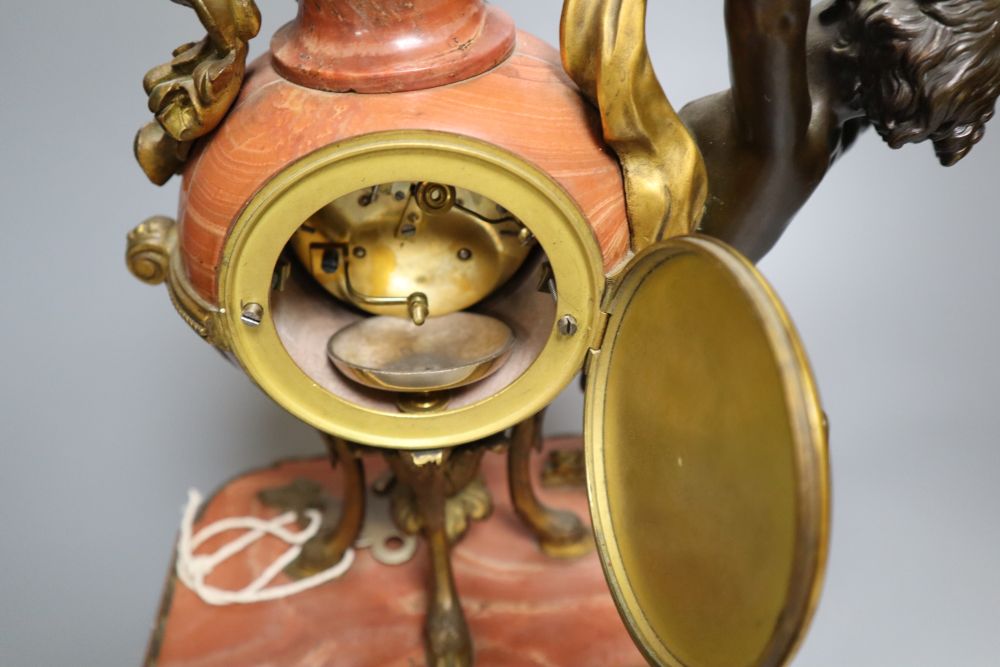 A 19th century French ormolu mounted rouge marble mantel clock, cast with putti, height 36cm